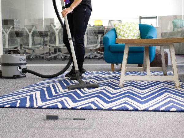 office-cleaning-services-nuserve A NuServe cleaner vacuuming a carpet.